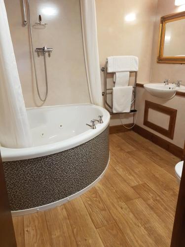 a bathroom with a bath tub and a sink at The Orkney Hotel in Kirkwall