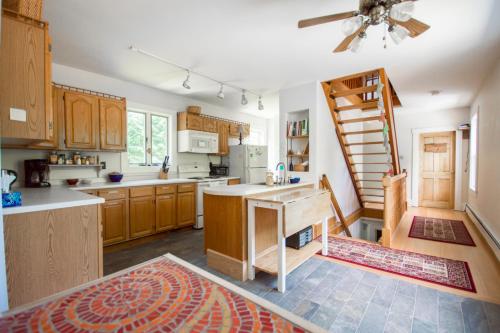 una cocina con armarios de madera y una escalera. en The Notch Hostel, en North Woodstock