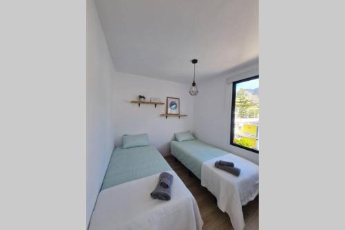 1 dormitorio con 2 camas y ventana en Baobab House, en Los Llanos de Aridane