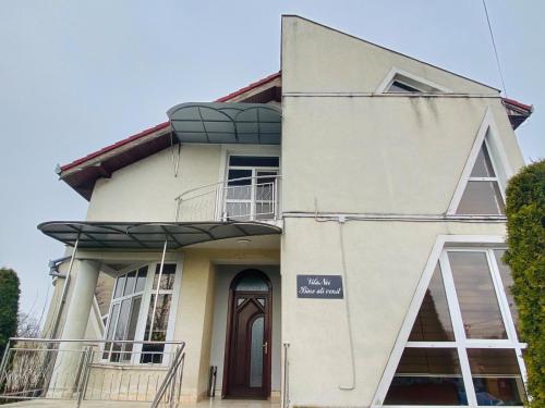 a white house with a sign on the front of it at Vila Nei in Lugoj