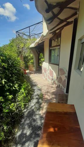 a porch of a house with a wooden bench at Recanto Flor Da Vida - Vale do Capao in Vale do Capao