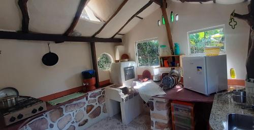 a kitchen with a counter and appliances in it at Recanto Flor Da Vida - Vale do Capao in Vale do Capao