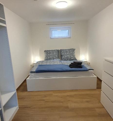 a bedroom with a bed with blue sheets and a window at Am Borgwallsee 2 in Steinhagen