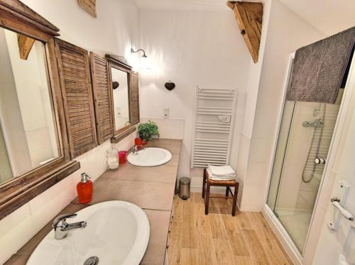 a bathroom with two sinks and a shower at Gîte avec piscine et jardin Le Cosy - Les Bergeronnettes Bergerac in Bergerac
