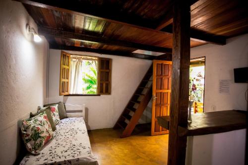 a living room with a couch and a stair case at Pousada Lumar in Caraíva