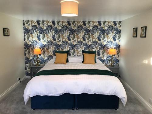 a bedroom with a large bed with a floral wallpaper at Hill Cottage in Weston-super-Mare