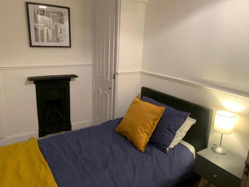 a bedroom with a bed with blue and yellow pillows at Number 48 in Salisbury