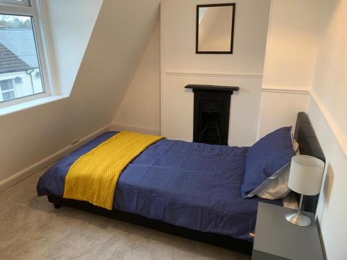 een slaapkamer met een bed met een gele en blauwe deken bij Number 48 in Salisbury