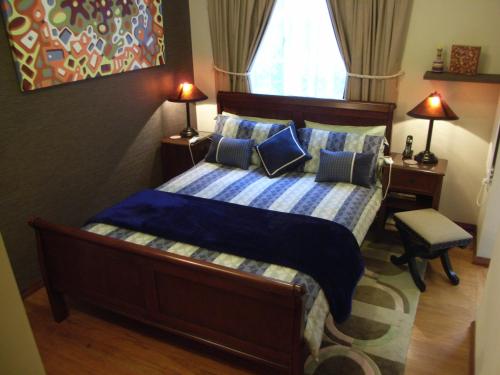 a bedroom with a bed with blue pillows at The Tuai Suite Waikaremoana in Tuai