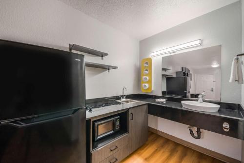 a kitchen with two sinks and a black refrigerator at Studio 6 Laredo, Tx - North I-35 in Laredo
