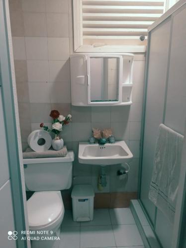 a small bathroom with a toilet and a sink at Hostal Poseidon del Mar in San Andrés