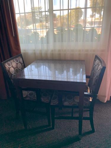 a table and two chairs with a table and a window at Morro Crest Inn in Morro Bay