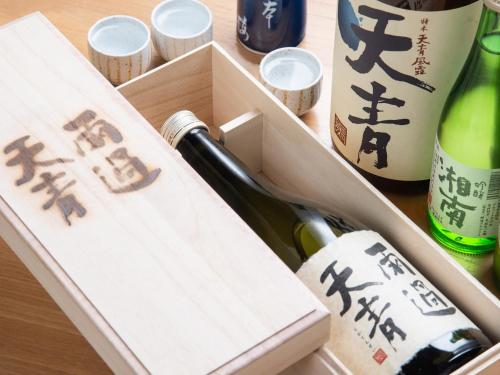 a wooden box with a bottle of wine and cups at Iwamotoro in Fujisawa