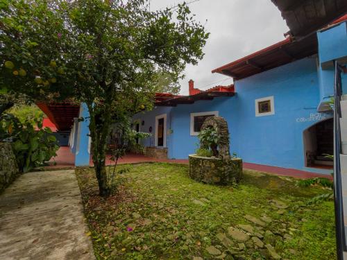 a blue house with a tree in front of it at Hotel Hacienda San Bartolo in Xico