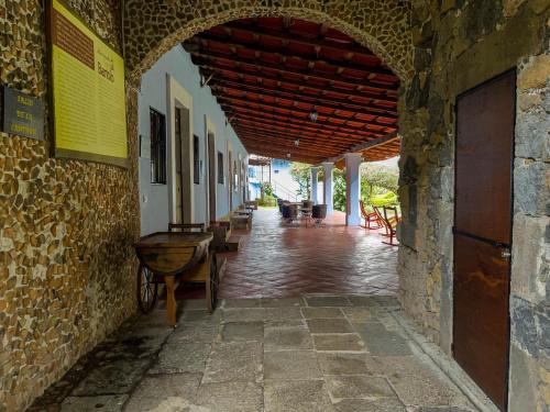 an archway in a stone building with a table and chairs at Hotel Hacienda San Bartolo in Xico