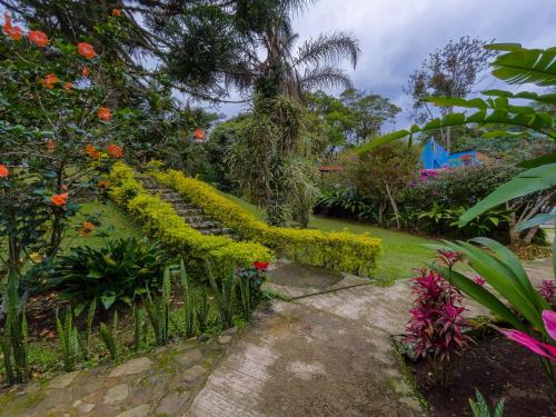 a garden with colorful flowers and a fence at Hotel Hacienda San Bartolo in Xico