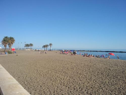 a group of people sitting on a beach at Apartamento Playa de Almería - Playa del Zapillo 2 in Almería