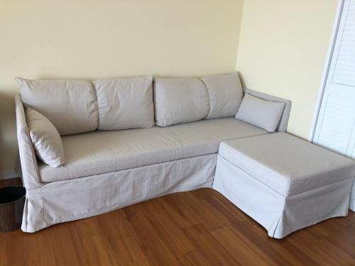 a white couch sitting in a living room at La Krasse Angelroad in Tonosho