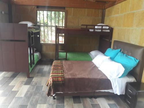 a bedroom with a bunk bed in a room at ECOCABAÑAS SAN PEDRO in Anapoima
