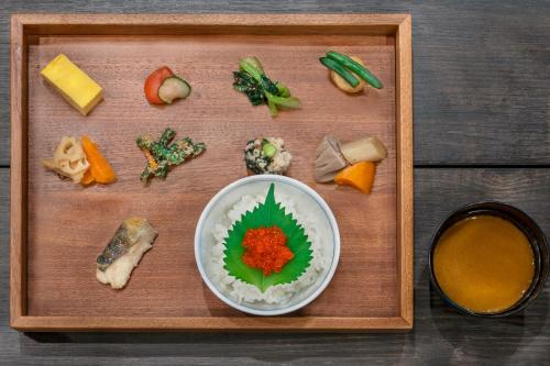 a wooden tray with vegetables and a bowl of food at Quintessa Hotel Sapporo in Sapporo