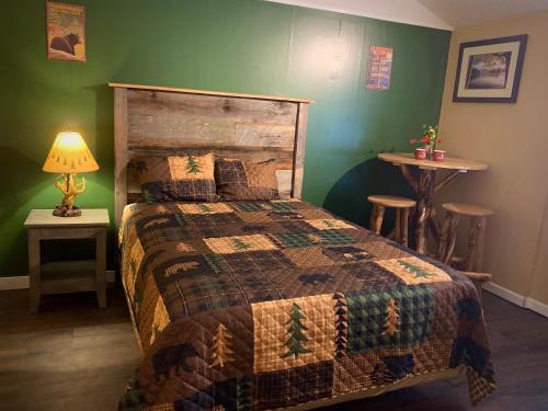 a bedroom with a bed and a green wall at Motel Montreal in Lake George