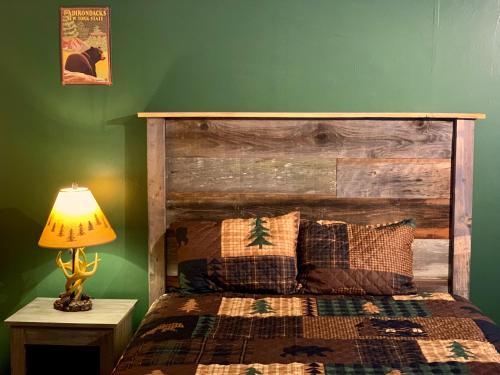 a bedroom with a bed and a lamp on a table at Motel Montreal in Lake George