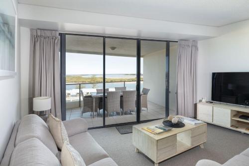 a living room with a couch and a television at The Waterford Prestige Apartments in Caloundra