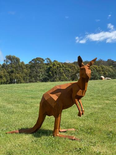 a statue of a brown kangaroo in a field at Hanging Rock Views in Woodend
