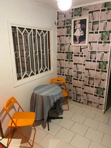 a room with a table and chairs and a wall of books at Homestay Studio in Yaoundé
