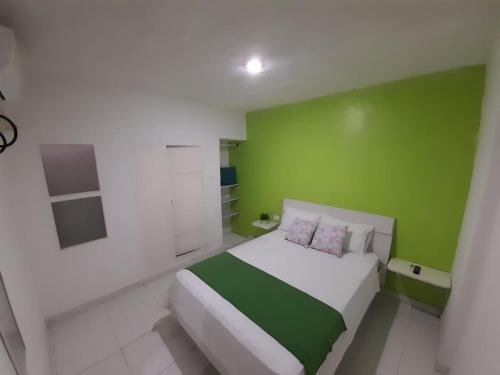 a green and white bedroom with a large bed at Tita’s Airport Hotel in Cartagena de Indias