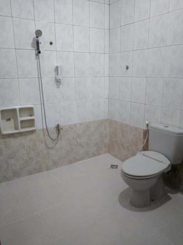 La salle de bains est pourvue de toilettes et d'une douche. dans l'établissement RUMAH PAKSI HOMESTAY, à Tanjungkarang