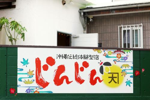 una señal que dice porcelana en un lado de un edificio en Okinawa Naha JinJin -沖縄伝統体験型宿じんじん- en Naha