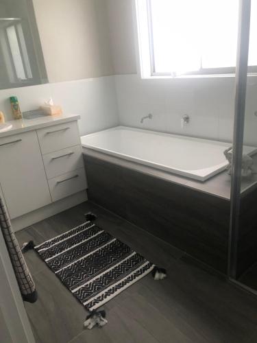a bathroom with a bath tub and a window at Brand new 4br get away 5min to albury city in Lavington