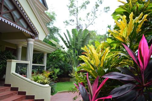 a house with a bunch of plants in the yard at Palm Grove Cottages - Leisure Resort in Benaulim