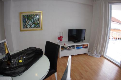 a living room with a table and a television at Apartments Lux in Makarska