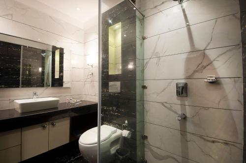 a bathroom with a shower and a toilet and a sink at Imperial Apartments Huda City in Gurgaon