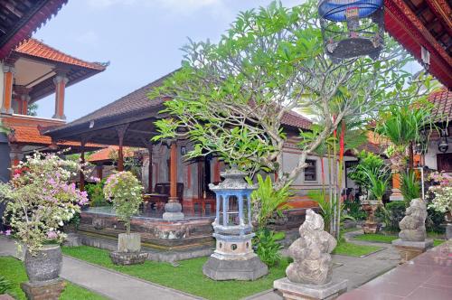 a house with a garden with plants in front of it at Nick's Homestay in Ubud