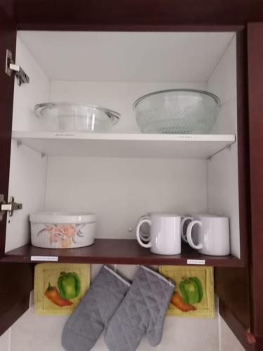a cupboard with some bowls and plates on it at 24 Topanga in Uvongo Beach