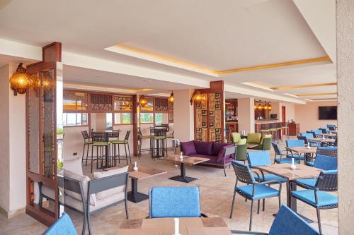 a restaurant with blue chairs and tables and tablesktop at Goma Serena Hotel in Goma