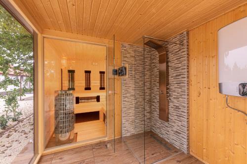 Cette chambre dispose d'une douche avec une porte en verre. dans l'établissement Nefelejcs Vendégház, à Tóalmás