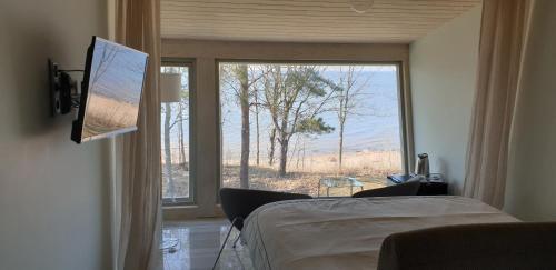 a bedroom with a bed and a large window at Guest House Vidlauči in Skulte