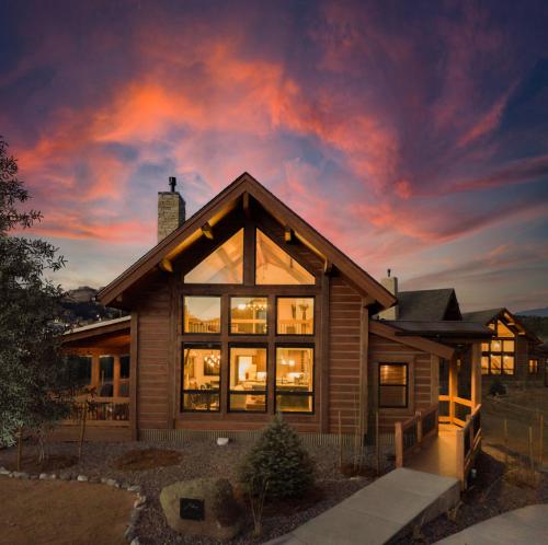 a house with a sunset in the background at Chic Retreat – Indoor/Outdoor Fireplace, Private Jacuzzi, Great Location! in Estes Park