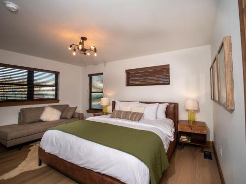 a bedroom with a large bed and a couch at Chic Retreat – Indoor/Outdoor Fireplace, Private Jacuzzi, Great Location! in Estes Park