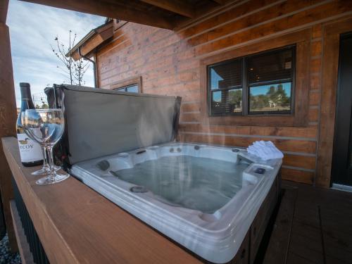 a large tub sitting on a table with a glass of wine at Chic Retreat – Indoor/Outdoor Fireplace, Private Jacuzzi, Great Location! in Estes Park
