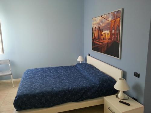niebieska sypialnia z łóżkiem i obrazem na ścianie w obiekcie Sony Affittacamere w mieście Desenzano del Garda