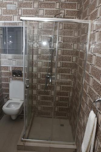 a bathroom with a glass shower with a toilet at Royal Luxury Hotels and Apartments in Kitwe