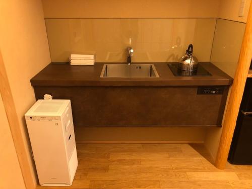 a kitchen with a sink and a refrigerator at 四季々々ぽんと先斗町の京町家 in Kyoto