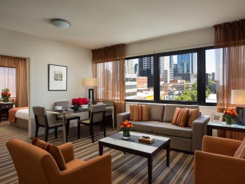 a living room filled with furniture and a large window at Somerset on Elizabeth Melbourne in Melbourne