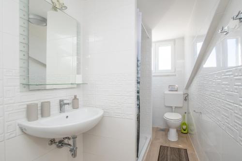 a white bathroom with a sink and a toilet at Historic Old Town apartment with the best view in town in Poreč