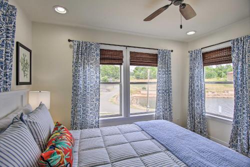 1 dormitorio con cortinas azules, 1 cama y ventana en Updated Lakefront Cottage Walk to Boat Ramp!, en Monkey Island